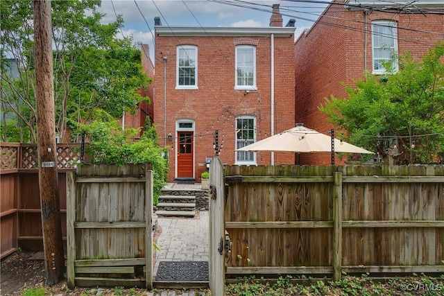 back of property featuring brick siding