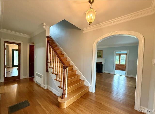 4210 Wistar Rd, Henrico, VA 23228 - stairway featuring arched walkways, a fireplace, ornamental molding, wood finished floors, and baseboards