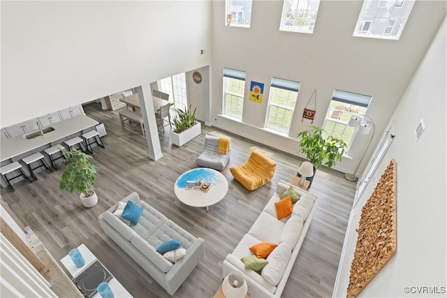 living room with a towering ceiling, wood finished floors, and baseboards