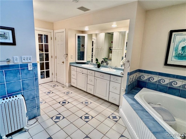 13300 Old Telegraph Rd, Providence Forge, VA 23140 - bathroom featuring radiator heating unit, double vanity, a garden tub, and tile patterned flooring