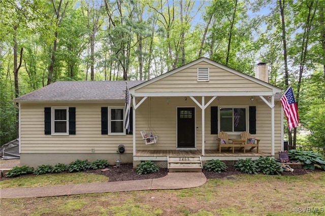2465 W Deerpath Dr, Powhatan, VA 23139 - view of front of home with a chimney, a porch, a shingled roof, and view of scattered trees