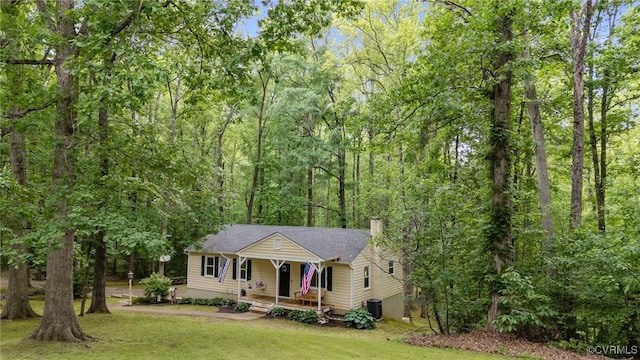 2465 W Deerpath Dr, Powhatan, VA 23139 - view of front of home with a porch, central air condition unit, a front lawn, a chimney, and a wooded view