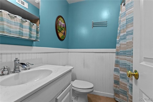 2465 W Deerpath Dr, Powhatan, VA 23139 - bathroom featuring wainscoting, toilet, vanity, tile patterned flooring, and curtained shower