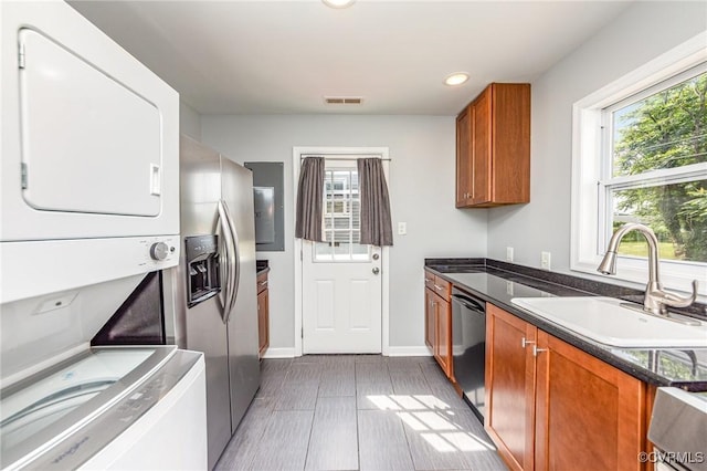 25 Cherry St, Petersburg, VA 23803 - kitchen featuring estacked washer and dryer, a sink, black dishwasher, stainless steel refrigerator with ice dispenser, and brown cabinets
