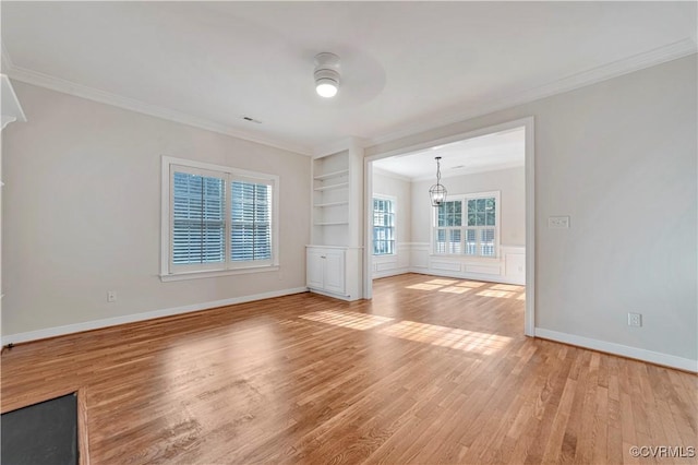 1355 Hawkins Wood Cir, Midlothian, VA 23114 - empty room with light wood finished floors, crown molding, a chandelier, built in shelves, and baseboards