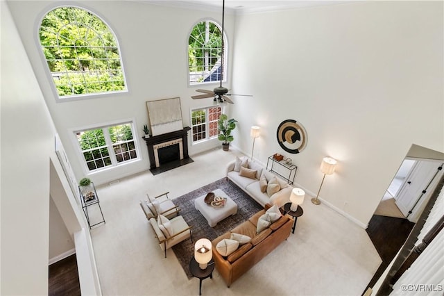 16412 Ravenchase Way, Moseley, VA 23120 - living room with a towering ceiling, a fireplace with flush hearth, a ceiling fan, ornamental molding, and carpet
