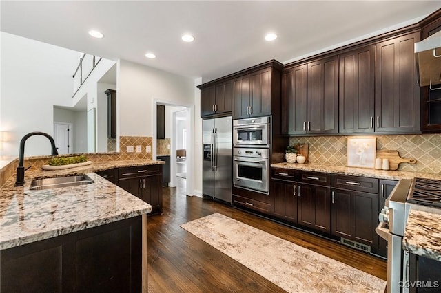 16412 Ravenchase Way, Moseley, VA 23120 - kitchen with stainless steel appliances, light stone countertops, dark wood-type flooring, backsplash, and dark brown cabinets