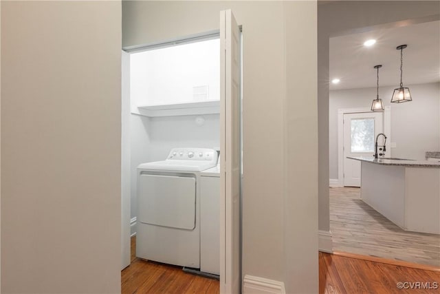 laundry room with washer / clothes dryer, light wood finished floors, baseboards, and recessed lighting