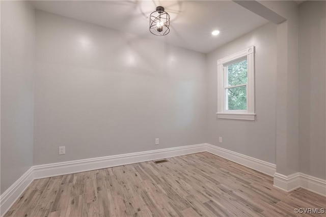 empty room with wood finished floors, baseboards, and recessed lighting