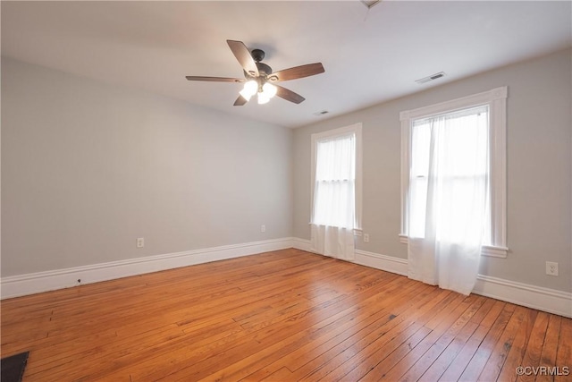 spare room featuring light wood-style flooring, baseboards, and ceiling fan