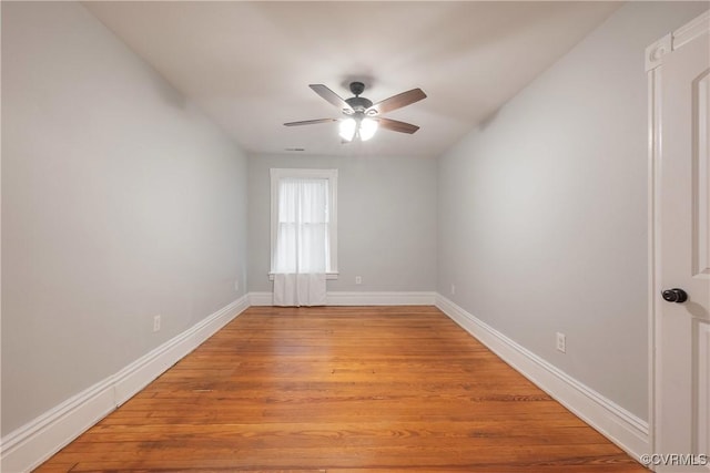unfurnished room with ceiling fan, light wood finished floors, and baseboards