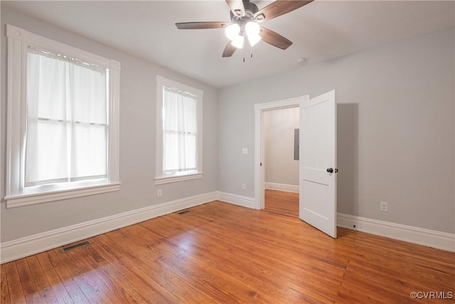 empty room with baseboards, light wood-style flooring, and ceiling fan