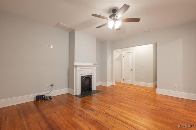 unfurnished living room featuring light wood finished floors, baseboards, and a ceiling fan