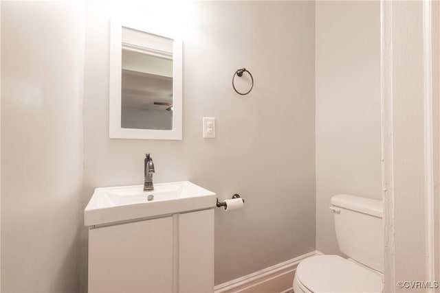 bathroom featuring toilet, vanity, and baseboards