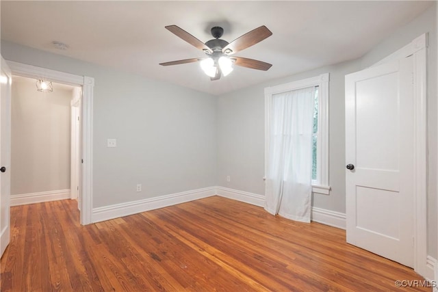 spare room with ceiling fan, baseboards, wood finished floors, and a smoke detector