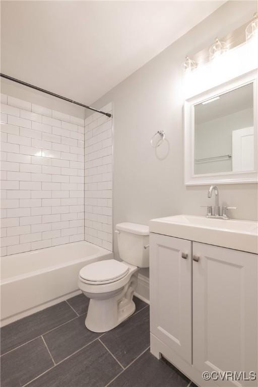 bathroom featuring tile patterned flooring, toilet, vanity, and shower / washtub combination
