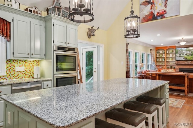 9226 Shelton Pointe Dr, Mechanicsville, VA 23116 - kitchen featuring a chandelier, appliances with stainless steel finishes, open floor plan, light stone countertops, and light wood-style floors