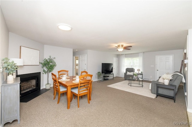 12727 Lodore Rd, Amelia Courthouse, VA 23002 - dining space with a fireplace with flush hearth, a ceiling fan, light carpet, and baseboards