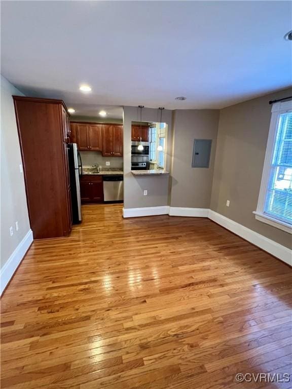 kitchen featuring stainless steel appliances, light wood-type flooring, baseboards, light countertops, and recessed lighting