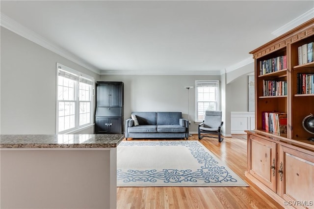 living room with ornamental molding and light wood-style floors