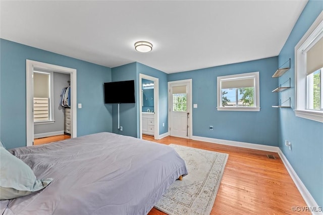 1415 N 25th St, Richmond, VA 23223 - bedroom with baseboards, wood finished floors, ensuite bath, and a spacious closet