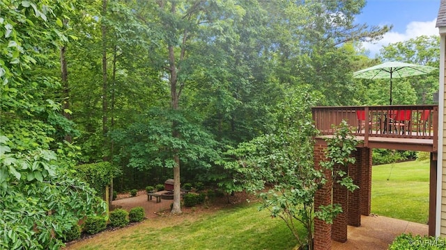 view of green lawn featuring a wooden deck