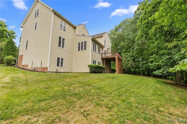 rear view of property with a yard and a wooden deck