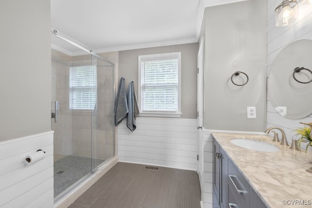 bathroom featuring crown molding, a stall shower, and vanity