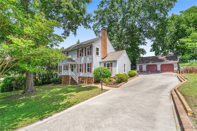 view of front of house with an outbuilding, a garage, and a chimney