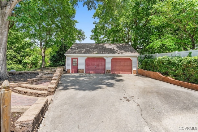 detached garage featuring fence