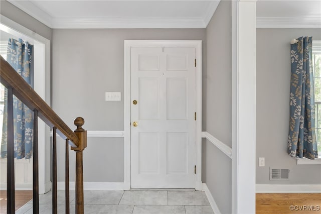 entrance foyer with crown molding and baseboards