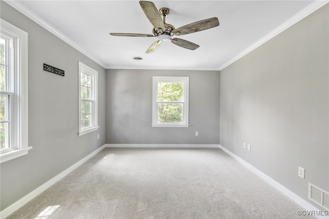 carpeted spare room featuring crown molding, baseboards, and a ceiling fan