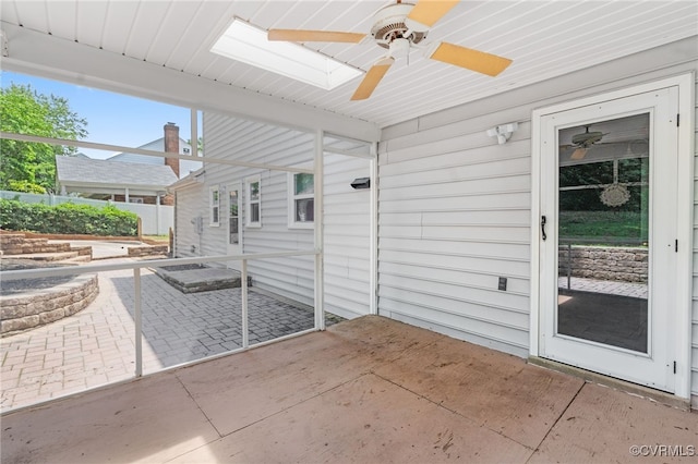 unfurnished sunroom with ceiling fan and a skylight