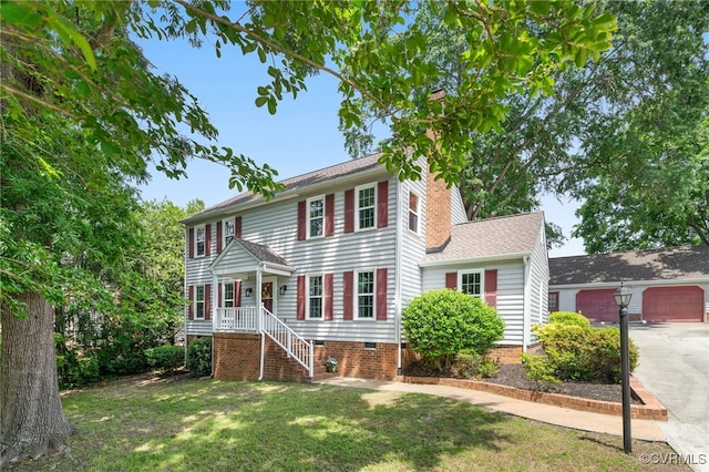 colonial house with a front lawn, a garage, crawl space, and a chimney