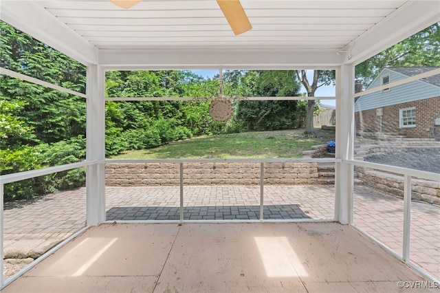 unfurnished sunroom with ceiling fan