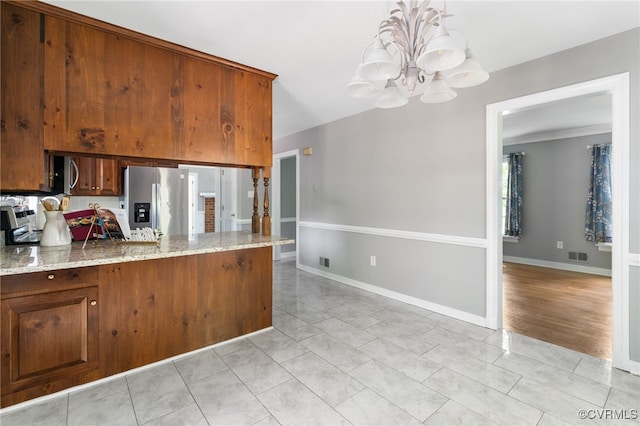 kitchen featuring stainless steel fridge with ice dispenser, a chandelier, baseboards, light stone countertops, and a peninsula