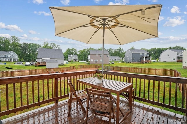 wooden terrace featuring a residential view and outdoor dining space