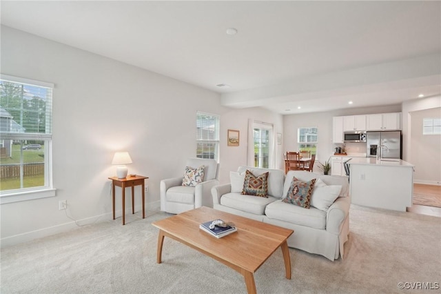 living area featuring plenty of natural light, baseboards, and recessed lighting