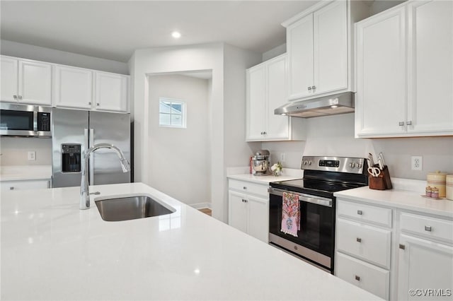 kitchen featuring under cabinet range hood, appliances with stainless steel finishes, a sink, light countertops, and recessed lighting