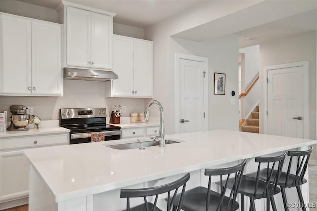 kitchen with stainless steel electric range, under cabinet range hood, a sink, and white cabinetry