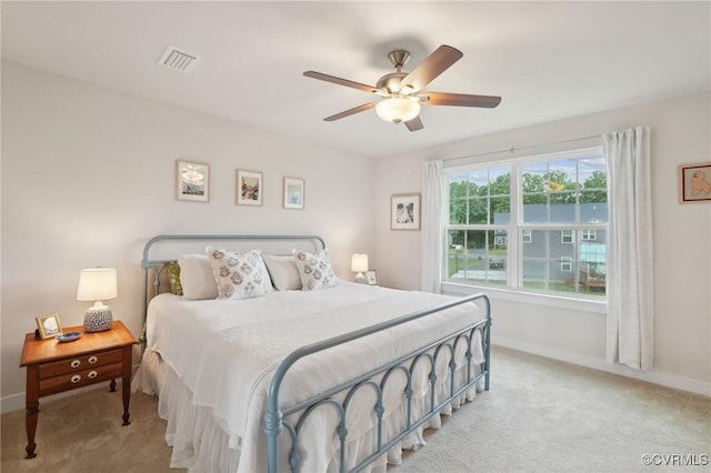 bedroom featuring light carpet, baseboards, and ceiling fan