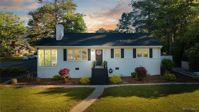 ranch-style house featuring a yard and a chimney