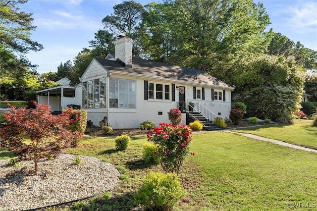 view of front of home with a chimney and a front lawn