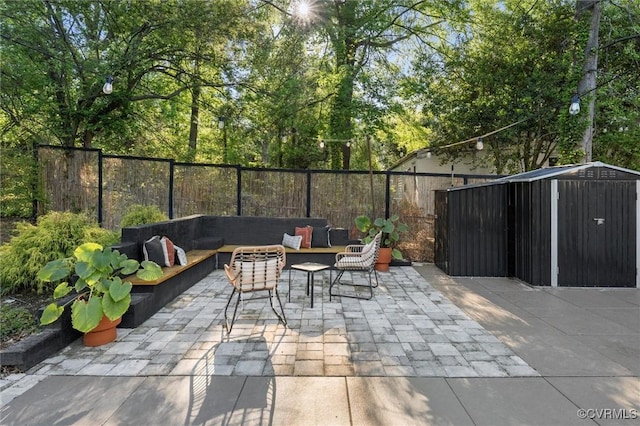view of patio / terrace featuring an outdoor hangout area, a shed, a fenced backyard, and an outdoor structure
