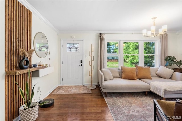living area featuring a chandelier, ornamental molding, wood finished floors, and baseboards