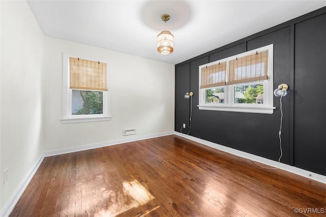 unfurnished room featuring wood finished floors and baseboards
