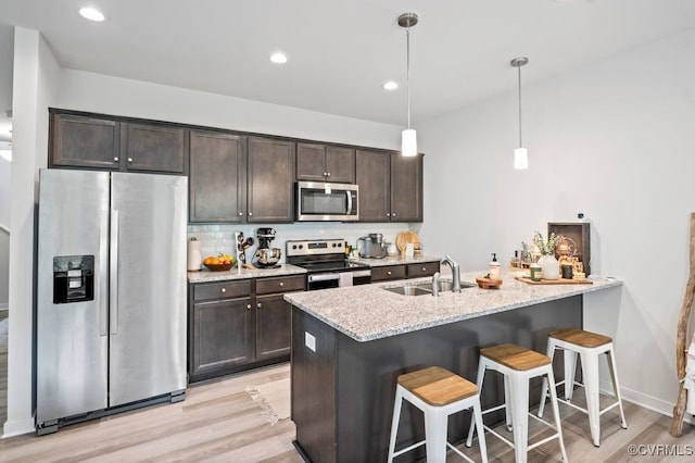 11348 Benton Pointe Way, Chester, VA 23831 - kitchen featuring appliances with stainless steel finishes, a sink, dark brown cabinets, light wood-style flooring, and a breakfast bar area