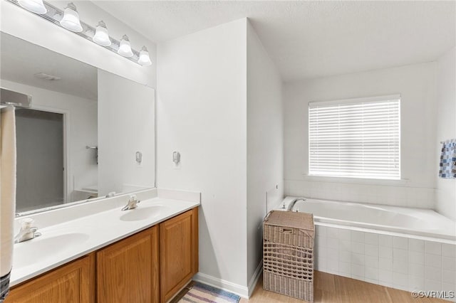 full bath featuring a bath and double vanity