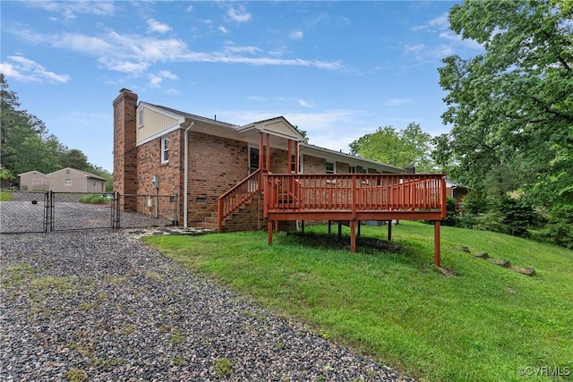 back of house featuring a gate, a chimney, brick siding, driveway, and a deck