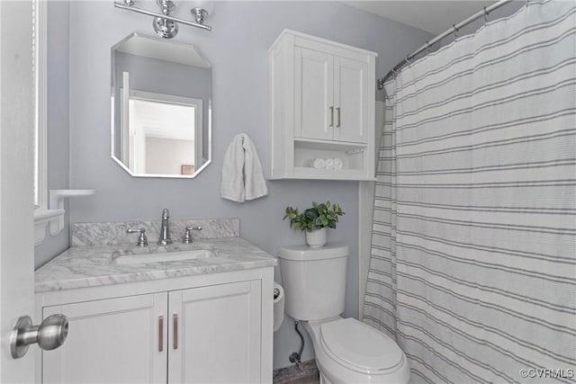 bathroom with vanity, toilet, and curtained shower